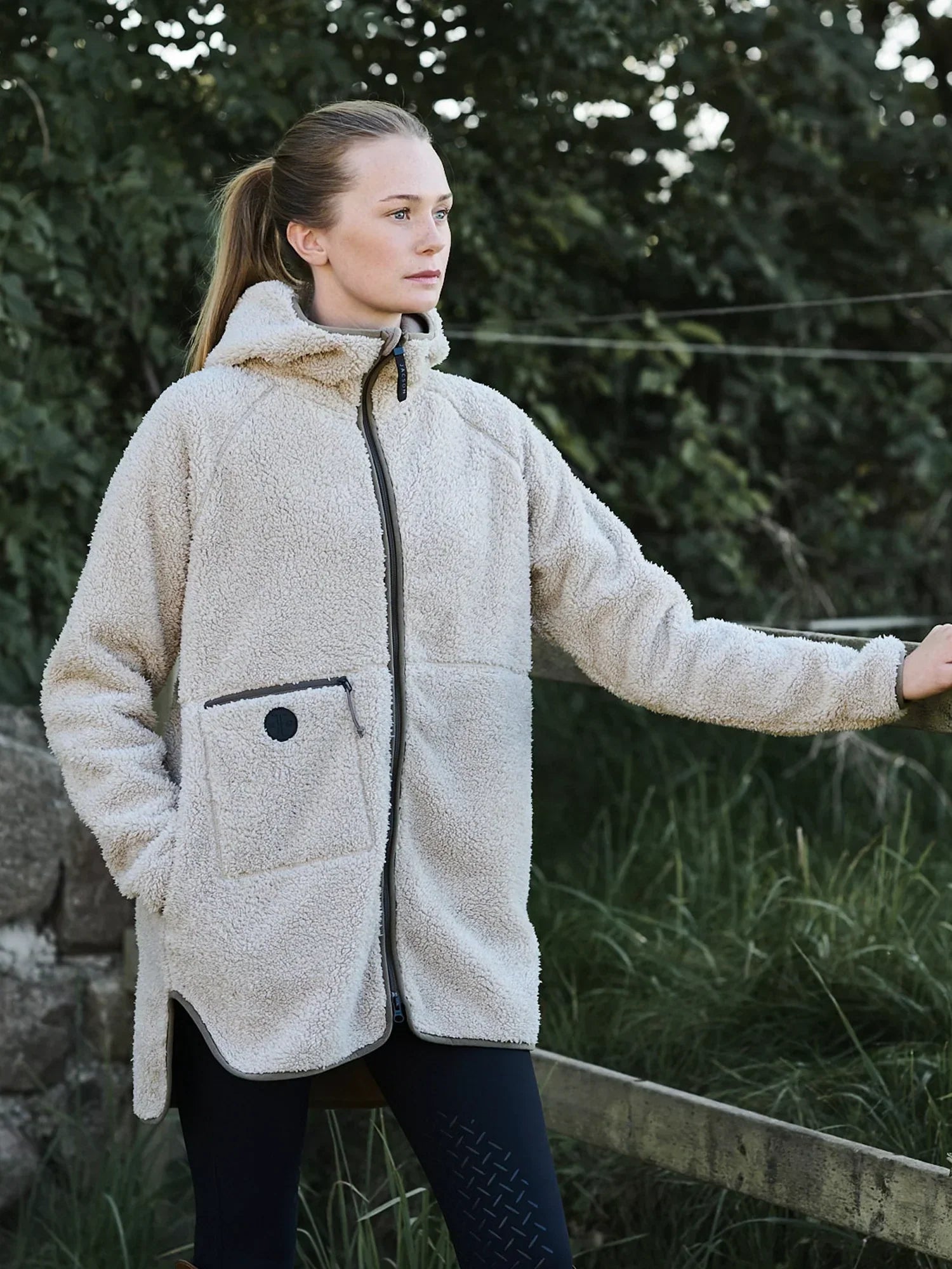 Oversized teddyjacka i mjukt teddyfleece med microfleece-insida, stor huva, tvåvägsdragkedja och praktiska fickor för stil och komfort i stallet.